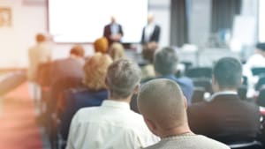 Présentation professionnelle devant un groupe de personnes assises.