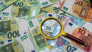 Des billets examins  travers une loupe.