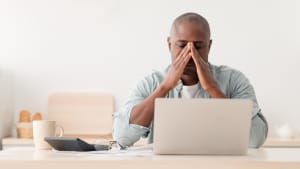 Un homme regardant son ordinateur l'air pr�occup�.