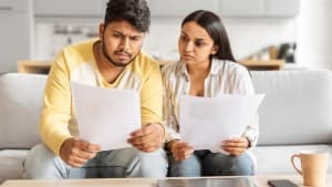 Un couple examinant des documents avec inquiétude.