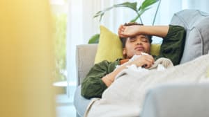 Une femme malade dans son canapé.