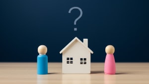 Deux figurines face à une maisonnette avec un point d'interrogation.