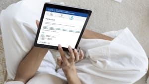 Personne utilisant une tablette pour naviguer sur un site web. Prime d'activit� CAF