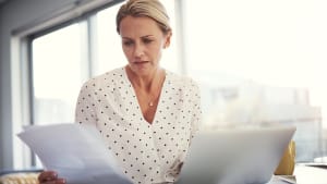 Une femme compare deux documents � son bureau.