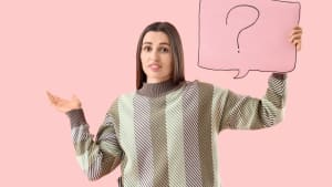 Une jeune femme tenant une bulle de discours avec un point d'interrogation sur un fond rose.