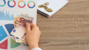 Une personne tenant des documents pr�sentant des diagrammes et des billets.