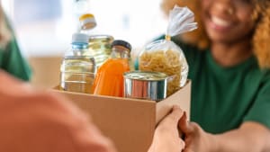 Quelqu'un tend un carton contenant de la nourriture � une autre personne.