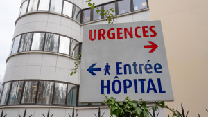 Un panneau avec URGENCES écrit en rouge et Entrée hôpital en bleu.