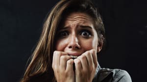 Portrait, sant� mentale et femme se rongeant les ongles en studio sur fond noir pour r�action � la peur ou � la panique. Visage, stress et horreur avec jeune personne effray�e dans le noir pour le drame, le cauchemar ou la terreur