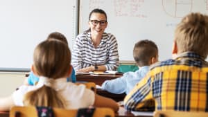 Une enseignante devant des enfants, en classe.