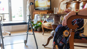 Personne �g�e � domicile avec d�ambulateur et t�l� alarme regarde la t�l�vision