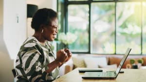 Finance, femme et succ�s avec un ordinateur portable � la maison pour l'approbation de pr�t, sans dette et �conomies.