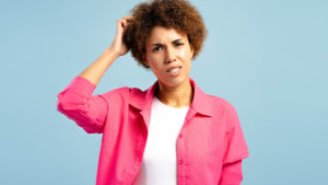 Femme confuse se grattant la t�te en prenant une d�cision difficile sur fond bleu