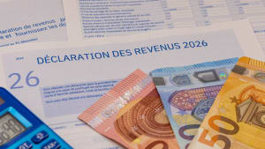 D�claration d?imp�ts, billets en euros et calculatrice bleue.