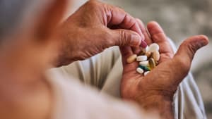 Pilules, m�dicaments et soins de sant� d'un homme �g� prenant des capsules quotidiennes pour une maladie chronique, un cancer ou la sant�. Bien-�tre, m�dication et vieillard malade avec des m�dicaments, des vitamines ou des suppl�ments dans sa main.