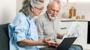 Un couple discute des factures et du budget tout en examinant les relev�s sur un ordinateur portable.