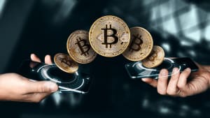 Deux mains �changent des bitcoins via smartphones num�riques.