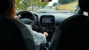 Une femme conduisant dans le village. Vue depuis le si�ge arri�re du passager.