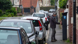 Un homme paie son stationnement.