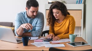 Jeune couple calculant leurs factures domestiques à la maison photo stock