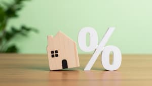 Maison en bois à côté d'un grand symbole pourcentage.