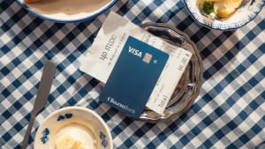 Carte bancaire et addition sur une table � carreaux bleus.