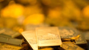 Lingots et pi�ces d'or empil�s, �clairage dor� et brillant.