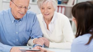 Un couple âgé consulte une femme pour des conseils.