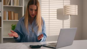 Une femme stressée devant un ordinateur.