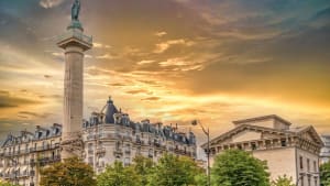 Colonne monumentale, b�timents parisiens, ciel dor� au coucher.