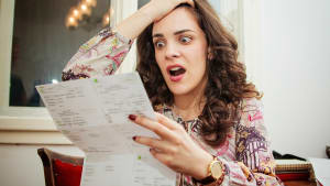 Une jeune femme choqu�e qui regarde un document.