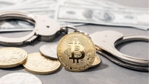 Concept de fraude li�e � la cryptomonnaie. Bitcoin et cryptomonnaies, menottes et billets de banque am�ricains.