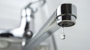 Une goutte d'eau pure qui tombe du robinet. Mise au point sélective.