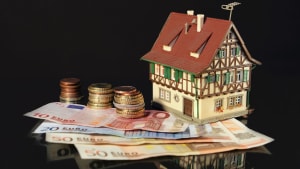 Maison miniature pos�e sur des billets et pi�ces d?euros.