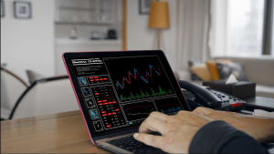 Personne analyse des graphiques financiers sur un ordinateur portable.
