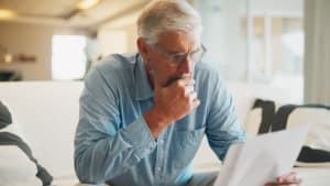Un homme regarde un document en s'interrogeant.