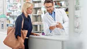 Un pharmacien montre un m�dicament � une patiente.