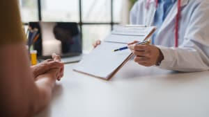 Le médecin présente un formulaire d'évaluation de santé au patient.