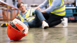 deux personnes portant un gilet jaune à terre après un accident du travail.