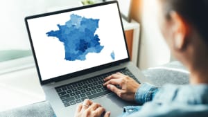 Personne regardant une carte de France colorée sur ordinateur.