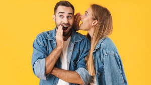 Image d'une femme heureuse chuchotant un secret � l'oreille d'un homme excit�