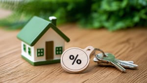 Maison miniature, clés et porte-clés avec symbole pourcentage.