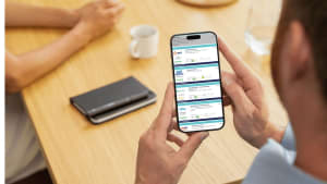 Un homme consultant le comparateur du m�diateur de l'�nergie sur son t�l�phone.