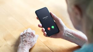 Appel téléphonique à une vieille femme par un arnaqueur ou un fraudeur. Une senior répond à un numéro inconnu. Concept d'escroquerie par smartphone ou canular mobile, usurpation d'identité ou phishing. Harceleur ou étranger. Grand-mère avec un téléphone portable.