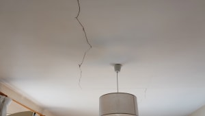 Une fissure visible au plafond au-dessus d'une lampe