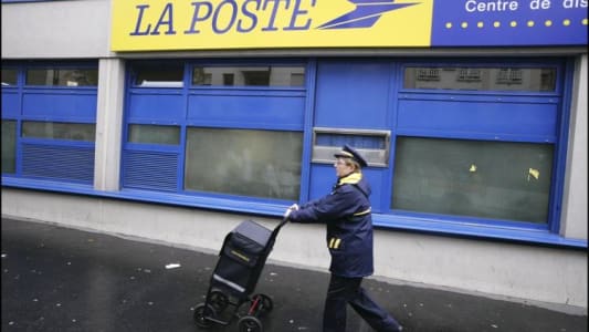 Une factrice face  un centre de tri