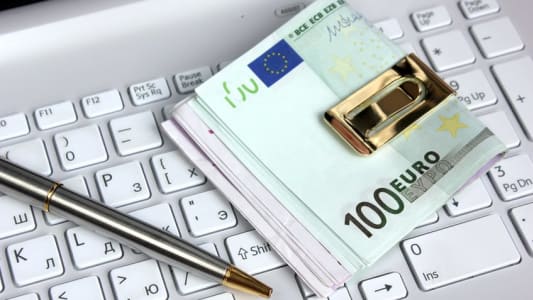 Un crayon et des billets sur un clavier