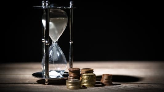 Un sablier et des pièces de monnaie