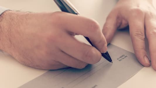 Homme remplissant un chque