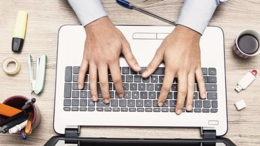 Homme tapant sur un clavier d'ordinateur